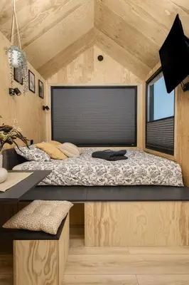 a bed in a tiny house with a window at Aurora Green Hill in Podobin