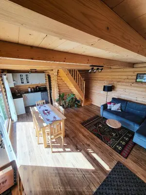 a living room with a table and a couch at Domki Na Grapie - z widokiem na Tatry in PyzÃ³wka
