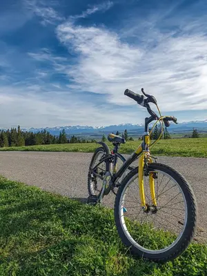 a yellow bike parked on the side of a road at Domki Na Grapie - z widokiem na Tatry in PyzÃ³wka