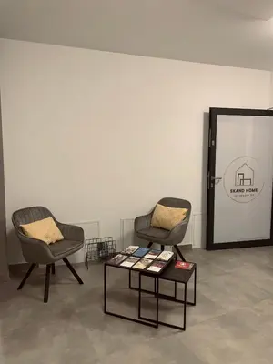two chairs and a table in front of a wall at Apartamenty Legionów 30 in Oświęcim