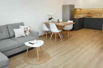 a living room with a couch and a table and a kitchen at Apartamenty Legionów 30 in Oświęcim