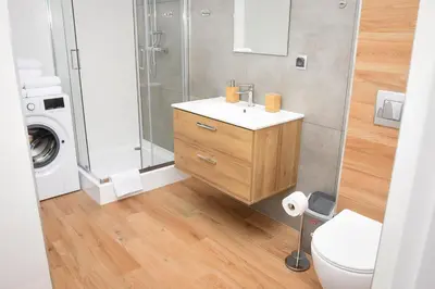 a bathroom with a sink and a washing machine at Apartamenty Legionów 30 in Oświęcim