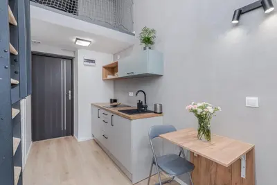 a small kitchen with a wooden table and a desk at Parkside Fresh Apartments - Old Town Guesthouse - by Upstairs in Kraków