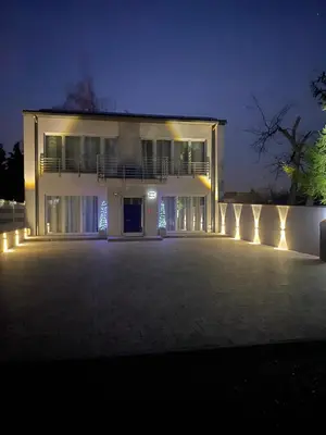 a large white building with lights in the night at Apartamenty in Miechów