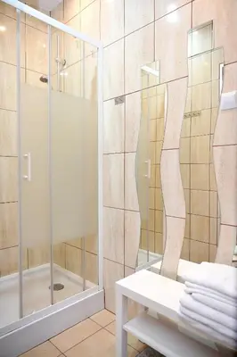 a bathroom with a shower with a glass door at Domek pod Zatorem in Ryczów