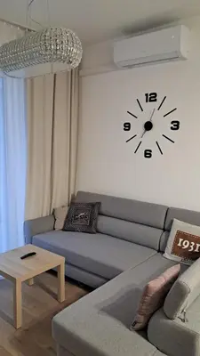 a living room with a couch and a clock on the wall at Apartamenty Vulcan in Zator