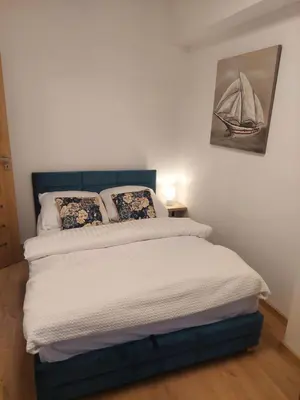 a bed in a bedroom with a picture of a boat on the wall at Apartamenty Vulcan in Zator