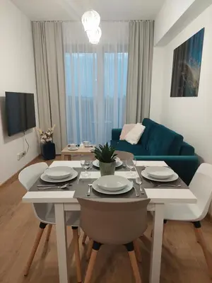 a living room with a table and a blue couch at Apartamenty Vulcan in Zator