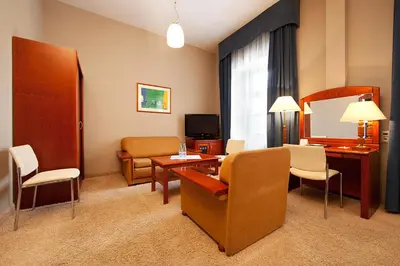 a hotel room with a desk and a living room at Blue Swan in Kraków