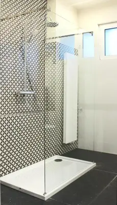 a shower with a glass door in a bathroom at Hotel Perła in Kraków