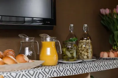 a table topped with jars of food and drinks at Hotel Perła in Kraków
