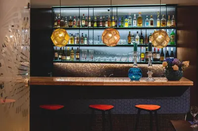 a bar with red stools in a restaurant at Hotel Perła in Kraków