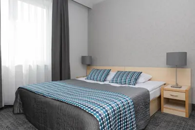 a bedroom with a bed with a blue and white blanket at Hotel Perła in Kraków