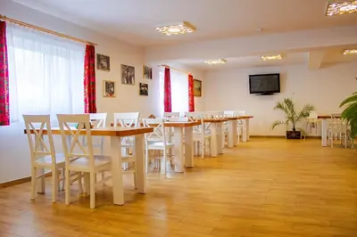 a conference room with tables and chairs and a television at Ranczo Zwierzyniec Noclegi in Jordanów