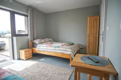 a small bedroom with a bed and a table at Ranczo Zwierzyniec Noclegi in Jordanów