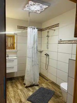 a bathroom with a shower and a shower curtain at Ranczo Zwierzyniec Noclegi in Jordanów