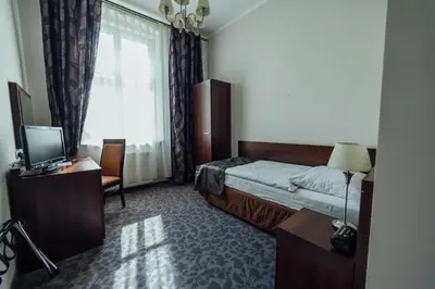 a hotel room with a bed and a window at Hotel Rezydent in Kraków