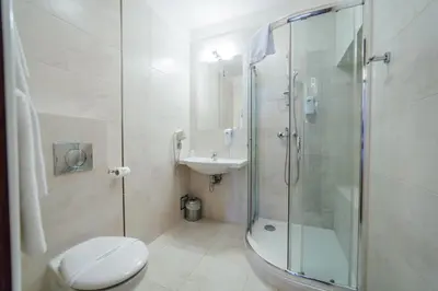 a bathroom with a shower and a toilet and a sink at Hotel Rezydent in Kraków