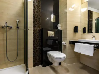 a bathroom with a toilet and a shower and a sink at Hotel Rezydent in Kraków