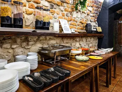 a table with plates of food and a grill at Hotel Rezydent in Kraków