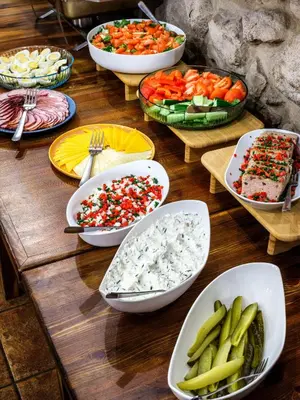 a table topped with bowls of food and vegetables at Hotel Rezydent in Kraków