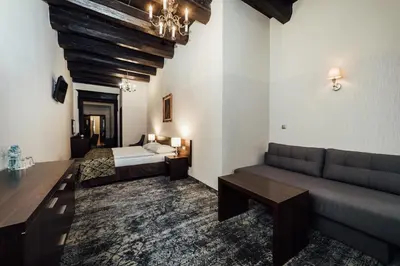 a living room with a couch and a bed at Hotel Rezydent in Kraków