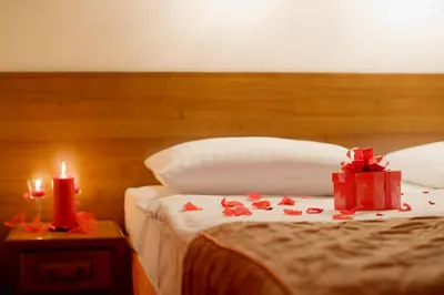 a bed with two presents and two candles on it at Hotel Regent in Kraków