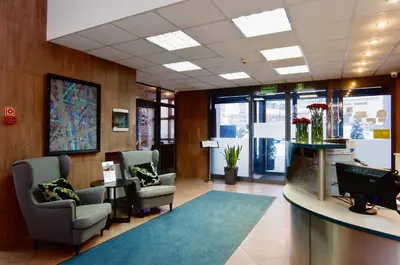 a waiting room with two chairs and a desk in a building at Hotel Galicya in Kraków