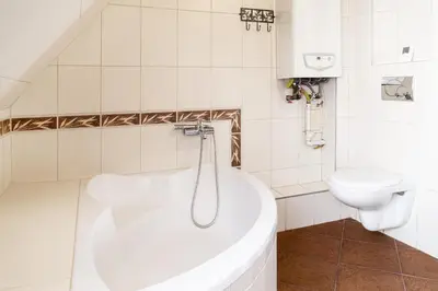 a white bathroom with a tub and a toilet at 2 Bedroom Apartment, Heart of Krakow Tomasza st in Kraków