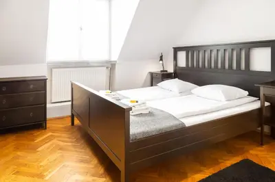 a bedroom with a large bed with white sheets at 2 Bedroom Apartment, Heart of Krakow Tomasza st in Kraków