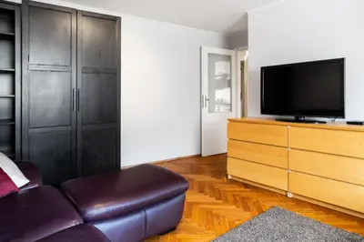 a living room with a couch and a tv on a dresser at 2 Bedroom Apartment, Heart of Krakow Tomasza st in Kraków