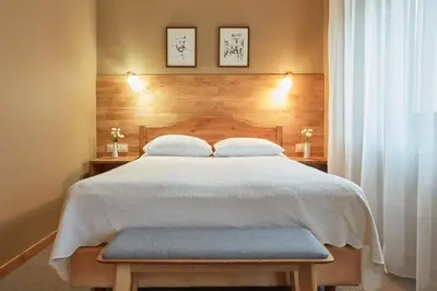 a bedroom with a large bed with a wooden headboard at Hotel Batory in Kraków