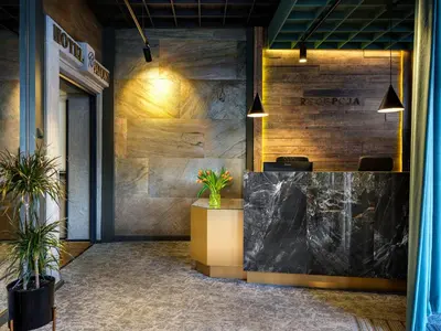 a lobby with a reception desk and potted plants at Hotel Batory in Kraków