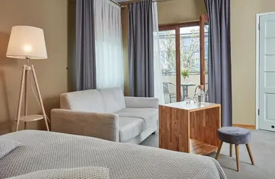 a bedroom with a bed and a couch and a chair at Hotel Batory in Kraków