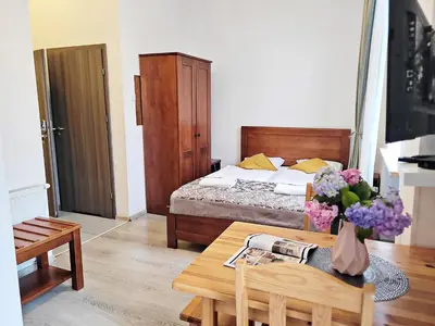 a bedroom with a bed and a table with flowers on it at DReAM Post Aparthotel in Kraków