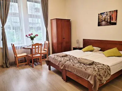 a bedroom with a bed and a table and chairs at DReAM Post Aparthotel in Kraków