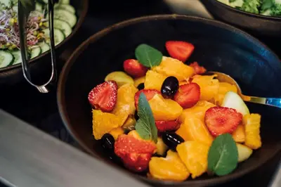 a bowl of fruit with a spoon in it at Vienna House Easy by Wyndham Cracow in Kraków