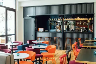a restaurant with tables and chairs and a bar at Vienna House Easy by Wyndham Cracow in Kraków
