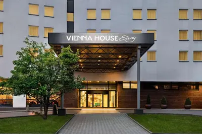 a building with a sign on the front of it at Vienna House Easy by Wyndham Cracow in Kraków