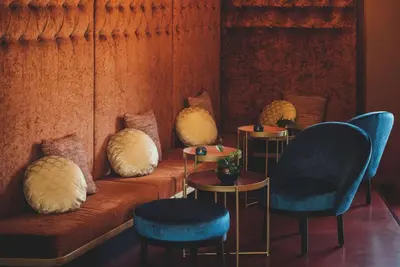 a room with a couch and two chairs and tables at Vienna House Easy by Wyndham Cracow in Kraków