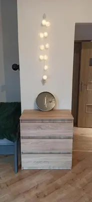 a clock on top of a dresser in a room at Daszyńskiego 7m3 in Kraków