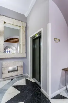 a hallway with a mirror and a door in a building at Hotel Elektor Premium in Kraków
