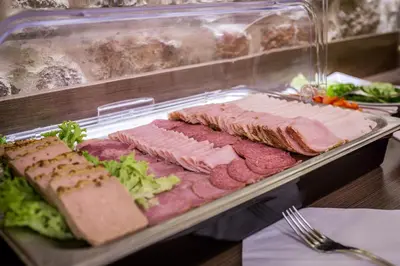 a tray of food with meat and vegetables on it at Hotel Elektor Premium in Kraków