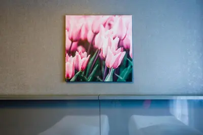 a picture of pink flowers hanging on a wall at Hotel Wyspiański in Kraków