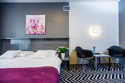 a hotel room with a bed and a table and chairs at Hotel Wyspiański in Kraków