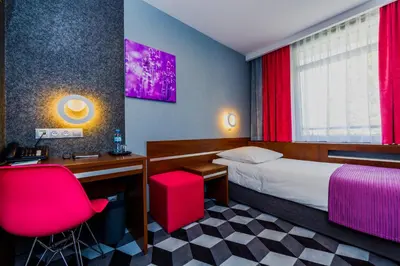 a hotel room with a bed and a desk and chair at Hotel Wyspiański in Kraków