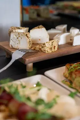 a table topped with plates of food with cheese at Hotel Atrium in Kraków