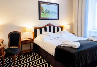 a hotel room with a bed and a chair at Hotel Senacki in Kraków