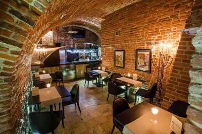a restaurant with tables and chairs and a brick wall at Hotel Senacki in Kraków