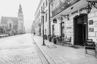 a black and white photo of a street with a building at Hotel Senacki in Kraków